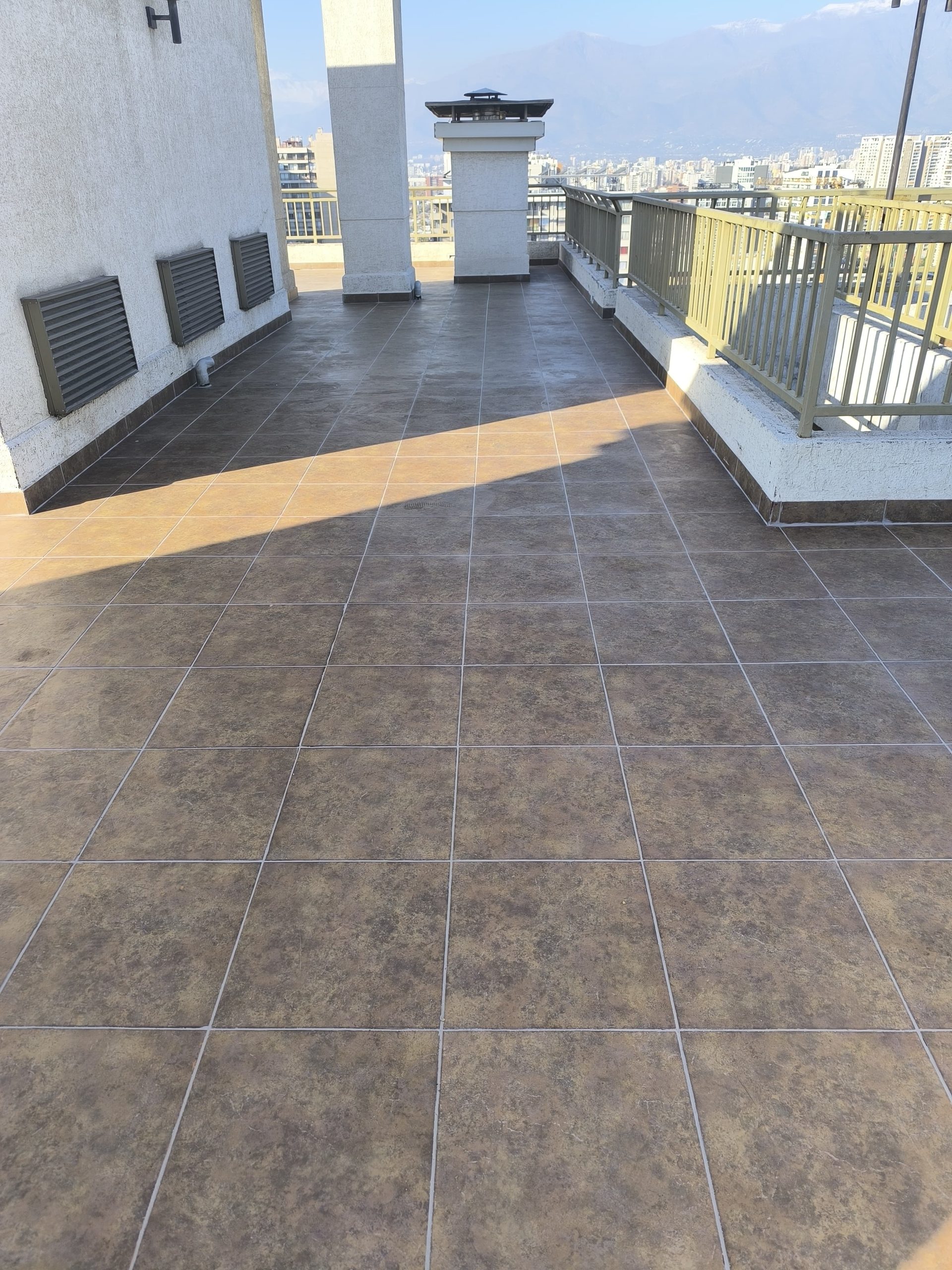 Reparación de terraza terminada en edificio de Santiago con vista a la ciudad y la cordillera